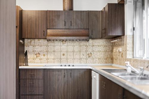 悉尼Premier Leichhardt Stayz的一个带木制橱柜和水槽的厨房