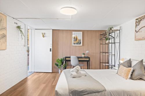 悉尼Premier Leichhardt Stayz的白色卧室配有一张大床和一张书桌