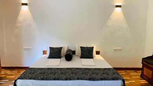 锡吉里亚Sigiriya Chena Villa的一间卧室配有一张大床和两个枕头