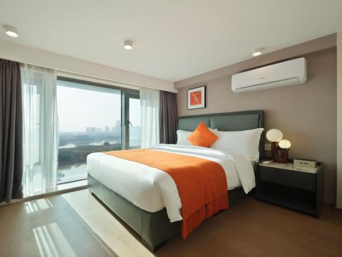 广州東枫酒店公寓（广州金融城三溪地铁站店）的一间卧室设有一张大床和一个大窗户