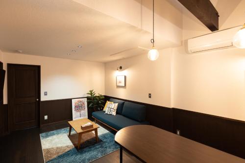 丰冈市城崎温泉一棟貸し　旅宿YaDOKARI的客厅配有蓝色的沙发和桌子