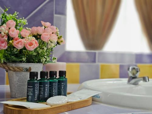 宜力Cottage Inn Gerik的浴室柜台,配有两瓶肥皂和鲜花