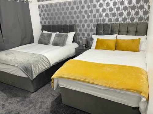 BraunstoneHometel Hidden Gem Large Comfy Home Can Sleep 13的卧室内两张并排的床