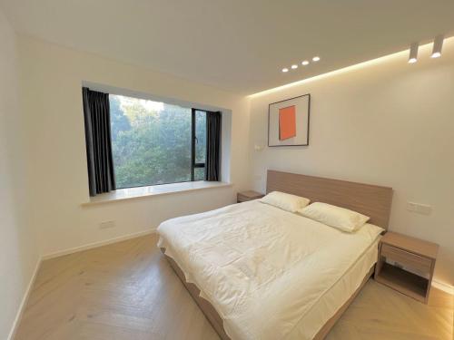 上海Shanghai Jing'an Modern Luxury Mansion 3 Bedrooms Near Metro & Attractions的一间卧室设有一张大床和一个窗户。