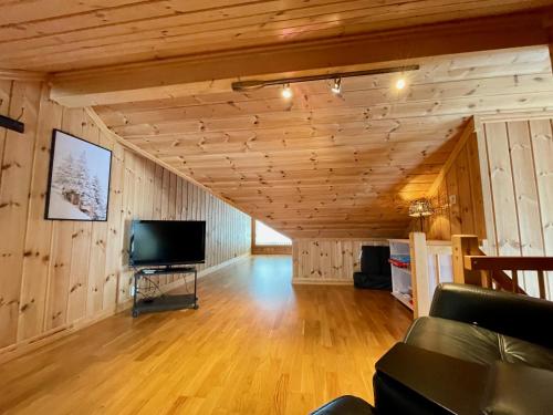 GaustablikkGausta Lodge med 6 sengeplasser i nærhet til Gaustatoppen的客厅设有木墙和平面电视。