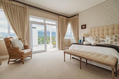 乔治White House on Kingswood Golf Estate的卧室配有床、椅子和窗户。