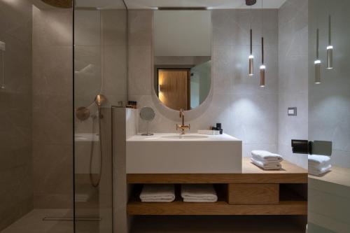 托罗尼Oniro Boutique Hotel的一间带水槽和镜子的浴室