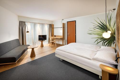 洛桑Alpha-Palmiers by Fassbind的客厅配有床和沙发