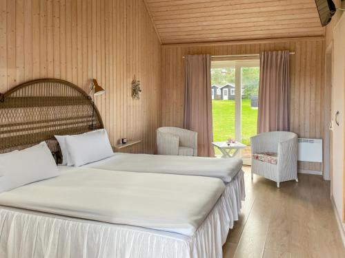 维斯特罗哈文Hotel Strandgaarden的一间卧室设有两张床和大窗户