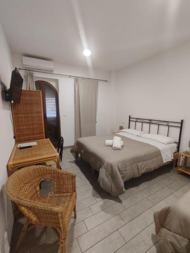 弗卡诺法拉辽内酒店的一间卧室配有两张床、一把椅子和一张书桌