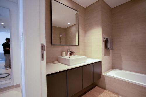 沙迦40 Minutes drive to Burj Khalifa的浴室配有盥洗盆、镜子和浴缸