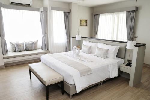 梭桃邑THE NAVY HOUSE HOTEL的卧室设有一张白色大床和两个窗户。