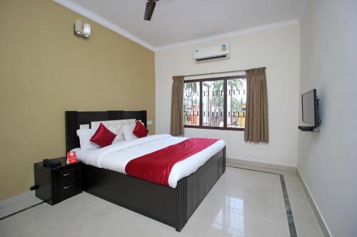 普里Hotel Sai Leela的一间卧室配有一张带红色毯子的大床