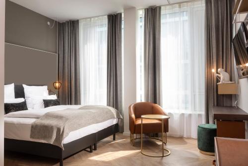 哈尔伯格摩斯Flightgate Munich Airport Hotel, a member of Radisson Individuals的配有一张床和一把椅子的酒店客房