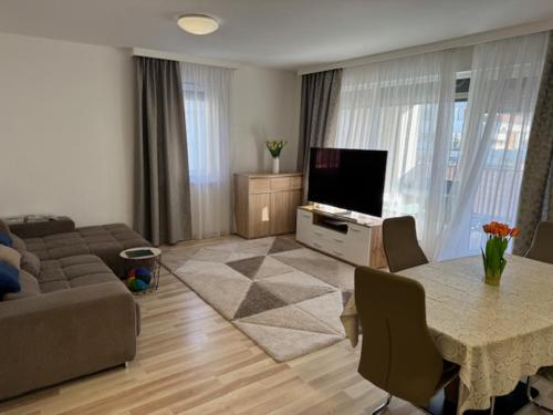 布达佩斯Luxury Cordia Apartment with free parking的客厅配有沙发和带电视的桌子