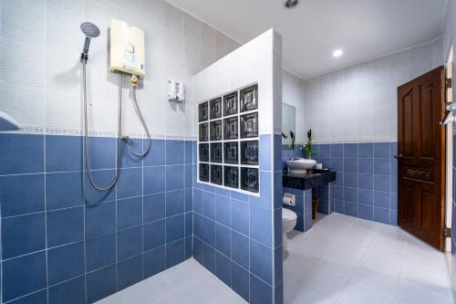 邦萨雷Siam Court Hotel and Resort的蓝色的浴室设有淋浴和卫生间。