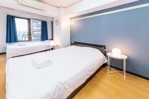 东京四谷松本館ビル的一间卧室设有两张床和蓝色的墙壁