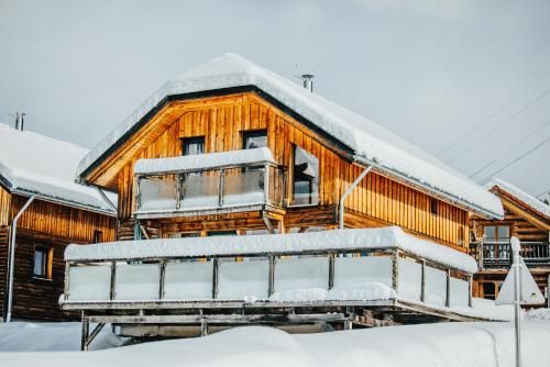 穆劳附近圣格奥尔根伍迪公园度假屋的屋顶上积雪的木屋