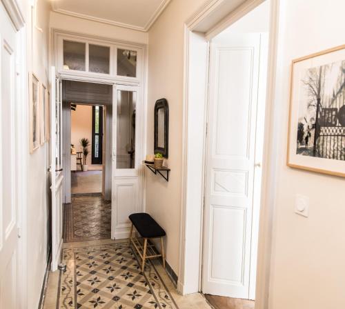 阿维尼翁拉蒂曼诗旅馆的走廊设有白色门,铺有瓷砖地板