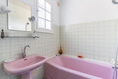 TrégarvanTy Ar Bleiz Gwenn - La maison du Loup Blanc的粉红色的浴室设有水槽和浴缸