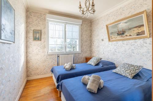 TrégarvanTy Ar Bleiz Gwenn - La maison du Loup Blanc的配有蓝色床单的客房内的两张床