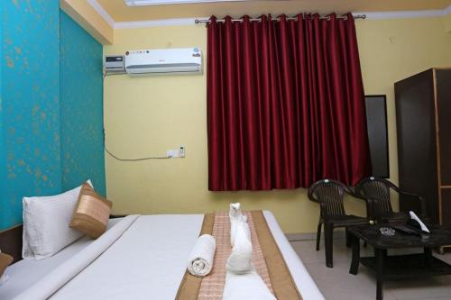 新德里Hotel Airport Plaza near Airport的一间卧室配有床和红色窗帘