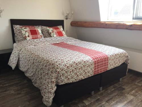 SpakenburgHoliday in Spakenburg Groof的一间卧室配有一张带红白毯子的床