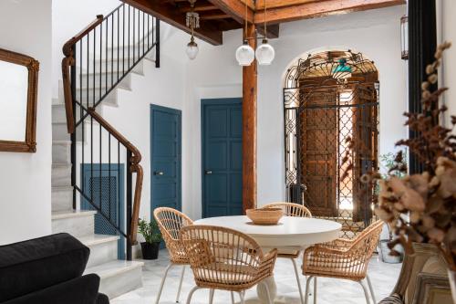 塞维利亚Magno Apartments Vírgenes Luxury House的一间配备有白色桌椅的用餐室