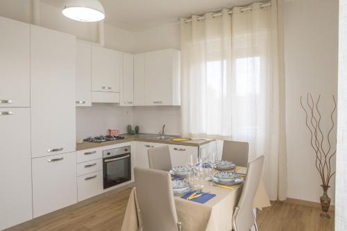 卡斯泰莱门多La Casa dei Racconti的厨房配有白色橱柜和桌椅