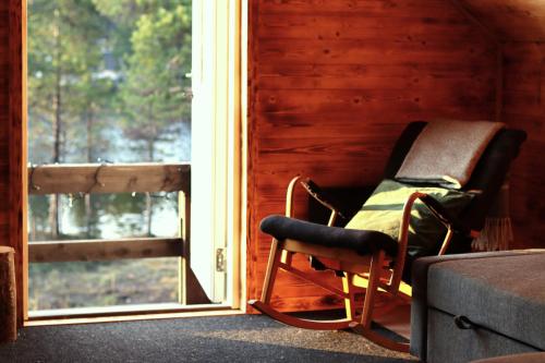 基律纳Cozy Cabin Styled Loft的窗户房间里摇椅