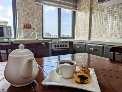 科托努Les Ombrelles Appart'Hotel的茶几,茶壶和咖啡