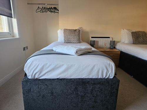 伊普斯威奇Modern 2 bedrooms apartment in Town Centre 10的一间卧室配有一张大床和一张搁脚凳
