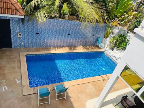 萨利尼亚拉尔Magnifique chambre avec accès piscine的享有带2把蓝色椅子的游泳池的顶部景致