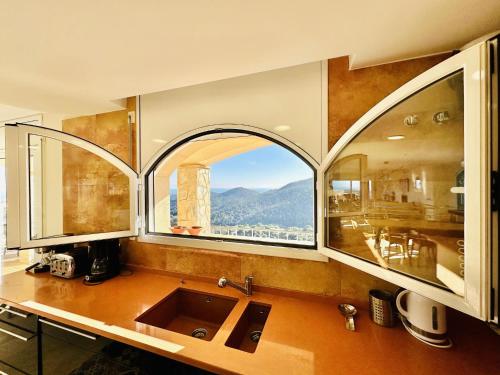 桑特费柳德吉克索尔斯Aurea CostaBravaSi的一个带水槽和大窗户的厨房