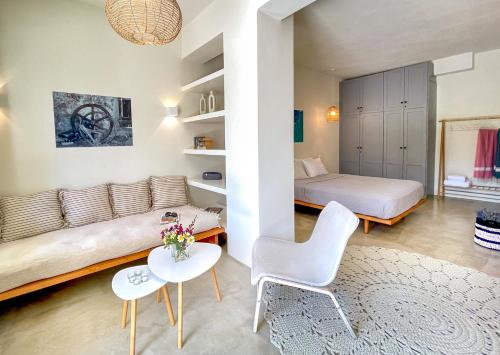 马克里亚罗斯Kynthia Suite - Escape to Seaside Makry Gialos的一间带沙发、床和桌子的卧室