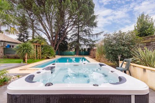 Biars-sur-CèreChambre d'hôtes - Espaces bien-être du "Dharma Vivant"的后院的热水浴池,设有游泳池