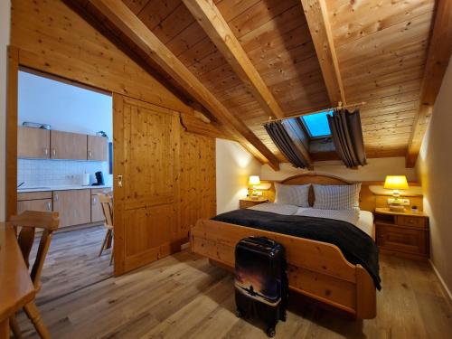 巴特科尔格鲁布HoFer am Zeitberg Ferienwohnung Windegg的卧室配有一张床铺,位于带木墙的房间内