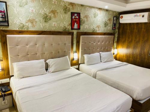 孟买New Hotel Amber International Near International Airport T2的配有白色床单的酒店客房内的两张床
