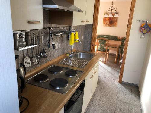 博尔滕哈根Haus-Koralle-Wohnung-rechts的厨房配有水槽和炉灶 顶部烤箱