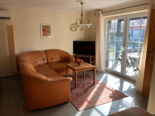 博尔滕哈根Haus-Koralle-Wohnung-rechts的客厅配有棕色皮沙发和桌子