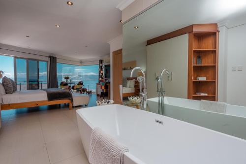干斯拜海之星旅舍的一间带床和浴缸的浴室以及一间卧室