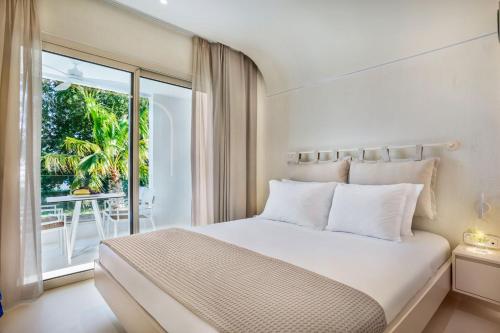 弗尔卡Cocoοns Luxury Suites & Villas的一间白色卧室,配有床和阳台