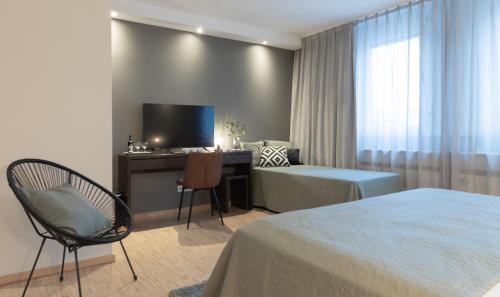 美因河畔法兰克福帕拉贡公寓式酒店的酒店客房配有一张床、一张书桌和一台电视。