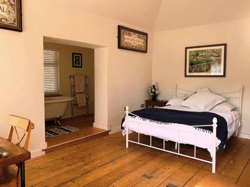 文特诺Smugglers Lodge at Ventnor Botanic Garden的卧室配有床和浴缸