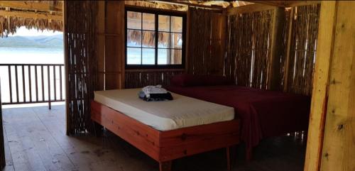 NusatupoCabañas sobre el mar en San Blas Narasgandub.的一间位于小屋内的卧室,配有一张床和一个窗户