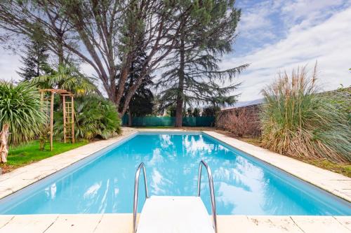 Biars-sur-CèreChambre d'hôtes - Espaces bien-être du "Dharma Vivant"的一个带滑梯的游泳池,位于一个树木繁茂的庭院内