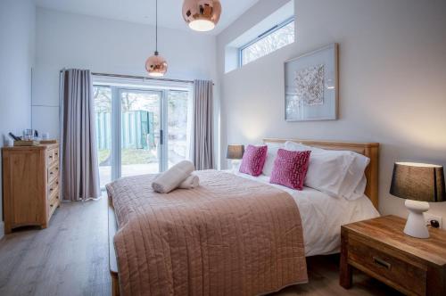 布雷肯Suite 12 - Sleeping Giant Hotel - Pen Y Cae Inn的卧室配有一张带粉红色枕头的大床