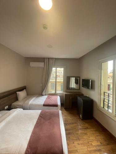 开罗New Lotus Hotel的酒店客房设有两张床和窗户。