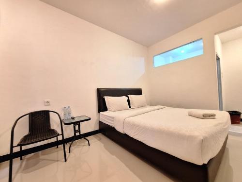 巴东Tanjung Syariah的卧室配有床、椅子和窗户。