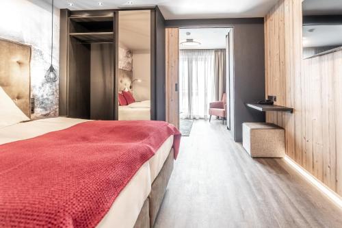 萨尔巴赫Hotel Astrid的一间卧室配有一张带红色毯子的大床